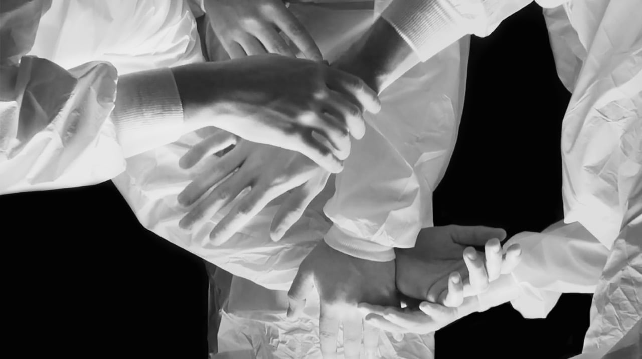 Bild ur "(im)perfekta koreografier" av c.off. Den svartvita bilden visar hopslingrande armar och händer. På armarna syns vita kläder.